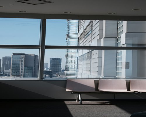 Close up of a person looking out of an office window over a city landscape