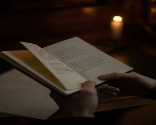 A person reading a book in a softly lit room